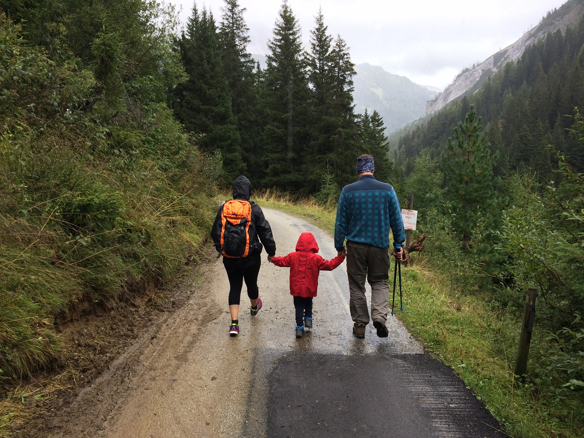 family walking down mountain path on cloudy day