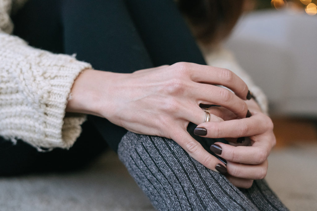 woman sitting on the floor holding wedding bands